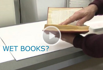 hands holding a wet book