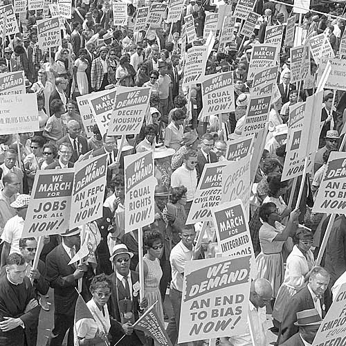 Demonstrators marching in the street holding signs
