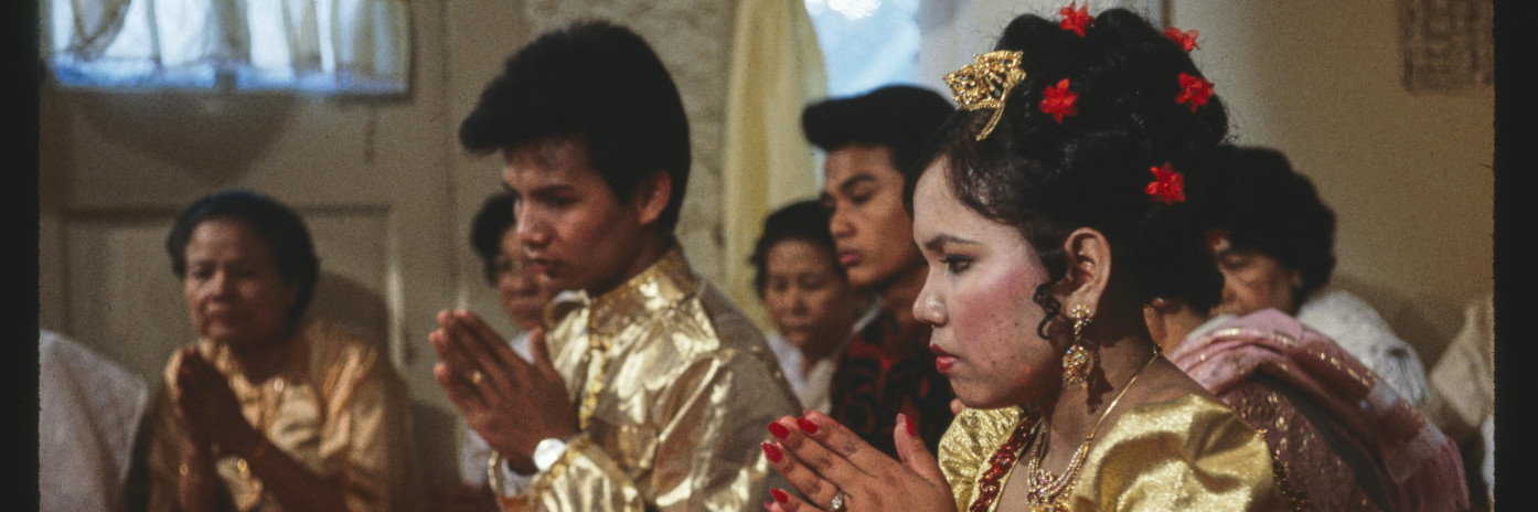 A woman and man sitting with their hands folded together