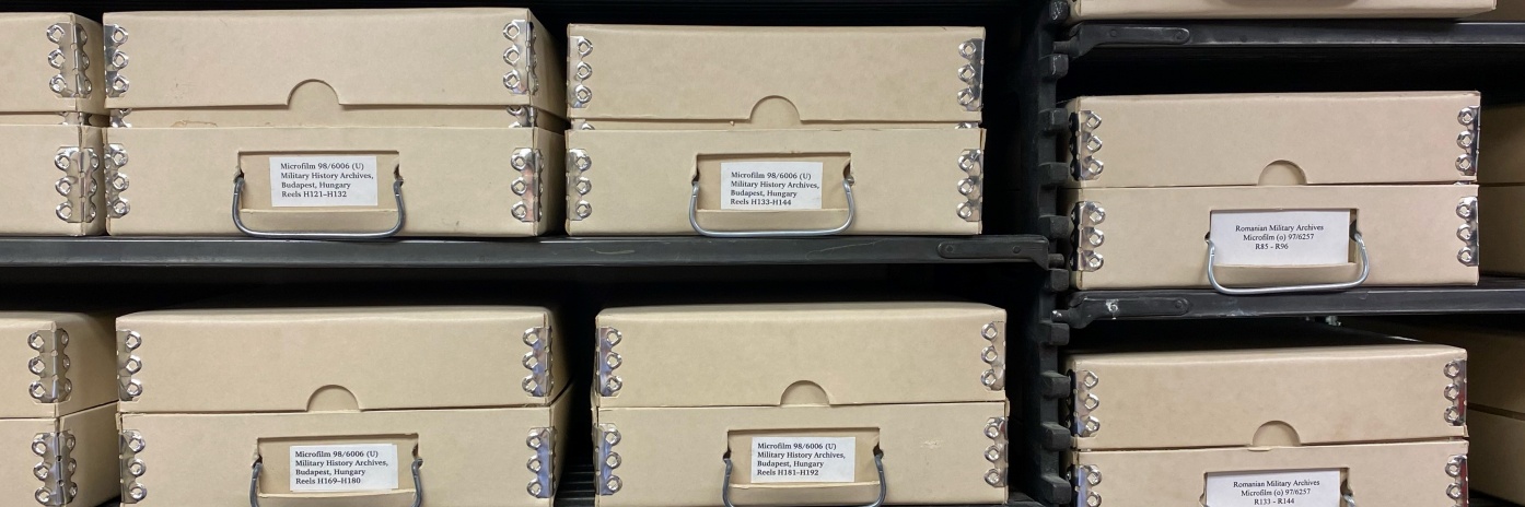 Stored containers of microfilm with labels, available for patrons to use
